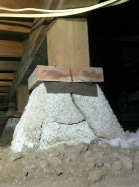 Worker reinforcing a structural support post inside a San Diego raised-foundation crawlspace